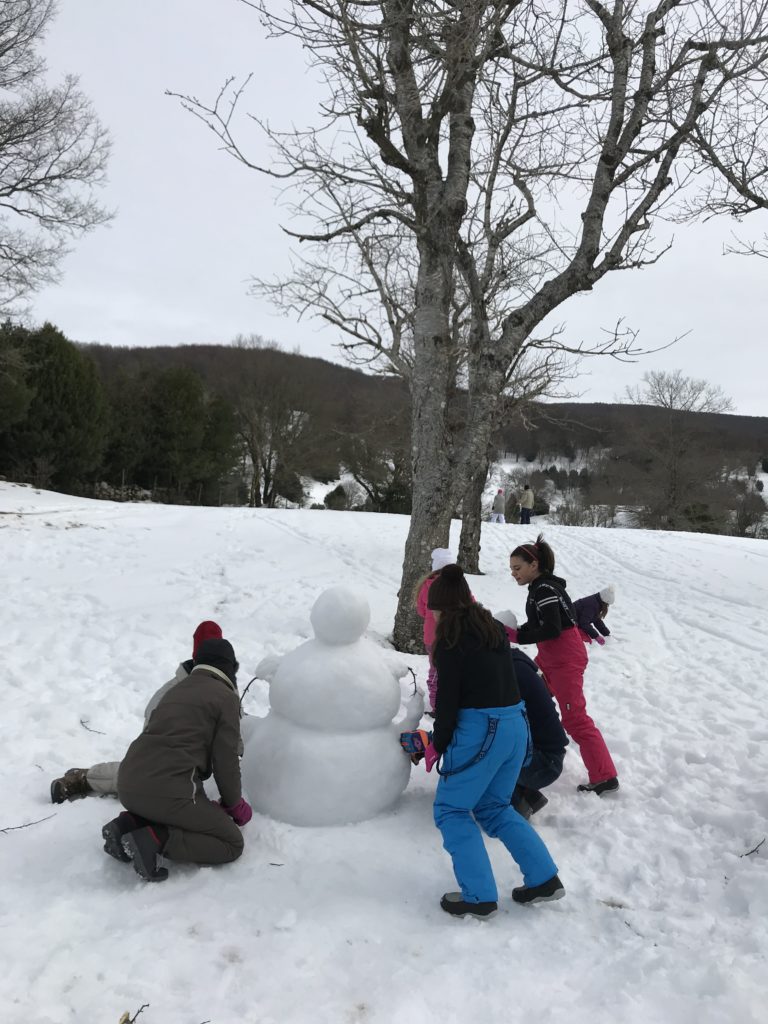 bambini che fanno un pupazzo di neve